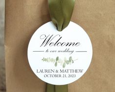 a brown paper bag with a green ribbon on it that says welcome to our wedding