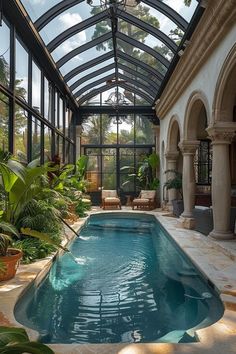 an indoor swimming pool surrounded by greenery