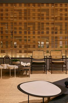 a living room filled with lots of furniture next to a wall covered in wooden slats