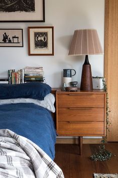 a bed room with a neatly made bed and pictures on the wall