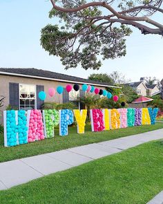 a yard with balloons that spell out the word happy