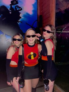 three women dressed up in costumes posing for the camera with one woman wearing sunglasses and holding her hand on her hip