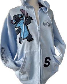 This Disney Stitch hoodie is perfect for any fan of the beloved character. The light blue color and stitch embroidered patches make it a unique addition to any wardrobe. The hoodie features a full zip closure, V-neckline, and regular long sleeves with a regular fit. It is made of a comfortable cotton blend material that is machine washable for easy care. The hoodie is great for all seasons, including winter, summer, fall, and spring, and can be worn for various activities such as basketball, run Lilo And Stitch Clothes, Oversized Embroidered Casual Hoodie, Blue Hooded Hoodie With Embroidered Graphics, Blue Embroidered Hooded Outerwear, Blue Long Sleeve Outerwear With Embroidered Graphics, Casual Embroidered Hoodie For College, Casual Embroidered Hooded Tops, Fitted Blue Hoodie Sweatshirt, Blue Embroidered Cotton Hoodie