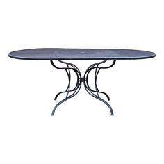 an oval table with wrought iron legs and a blue glass top, on a white background