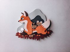 a paper cut out of a fox with two smaller foxes on it's back