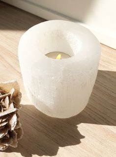 a white candle sitting on top of a wooden table