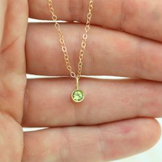 Very classy, simple, and dainty. This handcrafted gold pendant has a natural Peridot stone and comes on your choice of a 16 or an 18 inch gold chain with the artist's tag attached to the clasp. It can also be paired with other pendants! Mix and match to create your own personalized necklace or mother necklace! The pendant is also available without the chain, please make your selection when adding the item to your cart. Gold is 14ky. Stone measures 4mm in diameter. Birthstone for August. Comes wi Dainty Tiny May Birthstone Jewelry, Dainty 14k Gold Charm Necklace For May Birthstone, Dainty 14k Gold May Birthstone Charm Necklace, Minimalist 14k Gold Charm Necklace With May Birthstone, Minimalist May Birthstone Charm Necklace, Yellow Gold Dainty Necklace For May Birthstone, Dainty Yellow Gold Charm Necklace For May Birthstone, Minimalist Yellow Gold Charm Necklace For May Birthstone, Dainty Yellow Gold Charm Necklace With Emerald