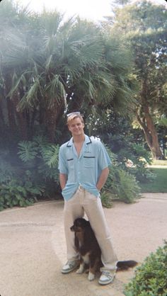 a man standing next to a brown and white dog