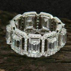 an image of a diamond ring on top of a piece of wood with diamonds around it