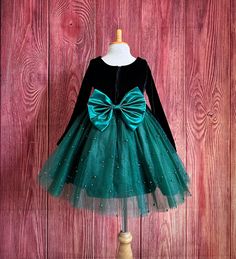 Little Darln Boutique  Our enchanting Knee Length flower girl dresses are sure to turn heads! This beautiful elegant sophisticated dress is handmade, the bodice consists of soft black velvet material, the back of the dress consists of a hunter green satin detachable bow, with zipper for closure. The skirt consists of 4 Hunter Green layers of tulle with the top layer consisting with sowed in pearl beads. The fifth layer is made of lining with crinoline for fullness.  Dress Is Pictured with a petticoat NOT INCLUDED https://www.etsy.com/listing/1316417982/white-knee-length-petticoat-wedding?click_key=41cb8b0ae4587efa582b0a433f3f5e0cde12aec0%3A1316417982&click_sum=af1df37b&ref=shop_home_active_1 Visit our store, more items to come!  https://www.etsy.com/shop/LittledarlnBoutique?ref=profile_hea Hunter Green Flower Girl Dress, Elegant Christmas Tutu Dress For Fancy Dress, Elegant Christmas Fancy Dress Tutu, Holiday Princess Dress With Bow, Green Christmas Princess Dress For Dress-up, Fitted Tutu Dress For Christmas Fancy Dress, Fitted Christmas Tutu Dress For Fancy Dress, Elegant Tulle Holiday Dress For Festive Occasions, Elegant Green Pageant Dress For Dress-up