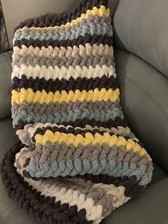 a crocheted blanket sitting on top of a couch