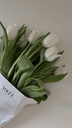 a bouquet of white tulips sitting on top of a piece of paper