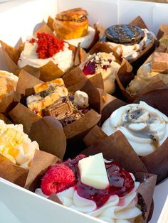 a box filled with lots of different types of cupcakes