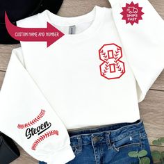 "Custom Baseball Sweatshirt, Baseball Mom Crewneck, Baseball Sweatshirt, Baseball Number Sweater, Baseball Sweatshirt, Baseball Personalized  ---------------------- 🛍️ How to Order Your Perfect T-Shirt 🌟 Welcome to our shop! We're thrilled you're here to customize your ideal T-shirt. To make your shopping experience seamless, follow these simple steps: 1️⃣ Explore All the Details: Take a close look at all the photos to ensure you know exactly what you're getting. 2️⃣ Size Matters: Use the convenient size chart in the dropdown menu and add each shirt to your cart one at a time. This ensures you get the perfect fit. 3️⃣ Color Your World: Select your favorite shirt color from the dropdown menu labeled \"Shirt Color.\" We offer a spectrum of choices to match your style. 4️⃣ Combine and Save: White T-shirt With Ribbed Cuffs For College, White Sportswear Top For Game Day, Varsity Long Sleeve Sports T-shirt, White Raglan Sleeve Sporty Sweatshirt, White Sports Sweater With Ribbed Cuffs, White Crew Neck Sweater For Game Day, Long Sleeve T-shirt For Baseball Season, White Sports T-shirt With Ribbed Cuffs, Varsity Style White Sweatshirt With Graphic Print