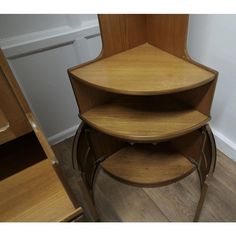 three wooden shelves stacked on top of each other in front of a wall and floor