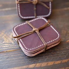 three leather coasters tied together on a wooden table