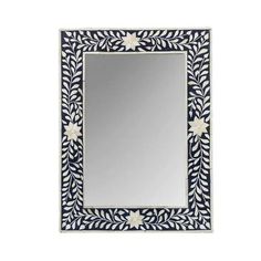 a blue and white mirror with leaves on the border, in front of a white background