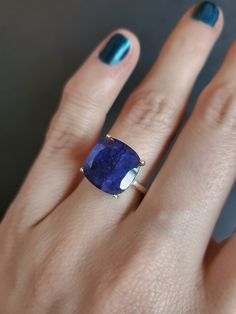 a woman's hand with a blue ring on it