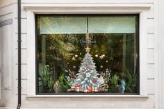 a decorated christmas tree in the window of a store