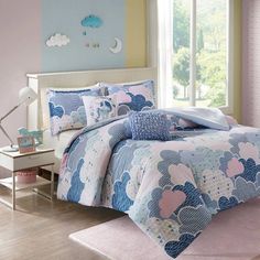 a blue and pink bed with clouds on it