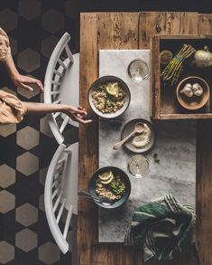 two people sitting at a table with bowls of food