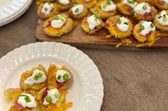 small appetizers are served on white plates and wooden trays next to each other