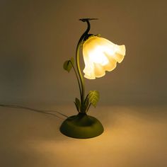 a lamp that is sitting on top of a table next to a light bulb in the shape of a flower