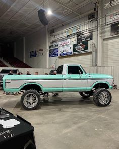 a large green and white truck parked in a garage