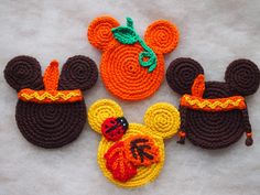 three crocheted mickey mouse ears and other items on a white tablecloth background