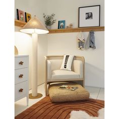 a white chair sitting on top of a rug next to a lamp