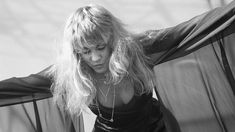 black and white photograph of a woman with her hair blowing in the wind, looking down