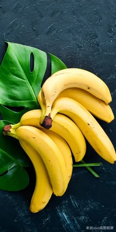 a bunch of ripe bananas sitting on top of a green leafy plant next to a banana peel