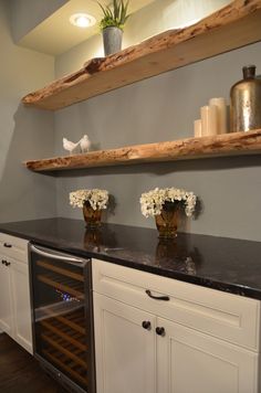 two vases with flowers sit on top of a counter in a wine tasting room