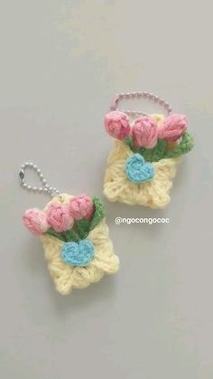 two crocheted keychains with pink and blue flowers on them are shown