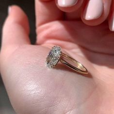 a close up of a person's hand with a ring on their finger and a diamond in the middle