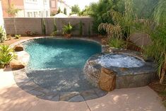 an outdoor hot tub in the middle of a backyard with trees and plants around it