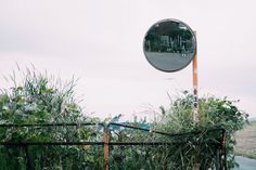 a mirror on the side of a metal fence