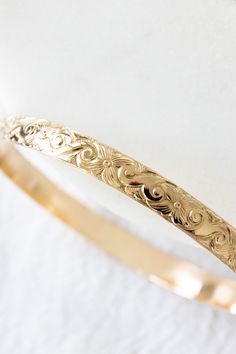 14k gold filled floral patterned bangle If you would like a different length that is not listed, please contact us for a custom order! Please note that there may be slight color variations or a seam where the joints of the bangle has been soldered. Since this piece is handmade, keep in mind that solder marks are visible and is totally normal. Finding Your Size We recommend using a flexible measuring tape to wrap around your hand/knuckles to find the length of your preferred fit. An alternative t Hand Knuckles, Hawaii Life, Jewelry Workshop, Swimwear Online, Jewelry Repair, Measuring Tape, Toe Rings, Wrap Around, Keep In Mind