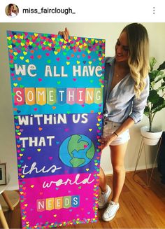 a woman holding up a sign that says we all have something within us that world needs