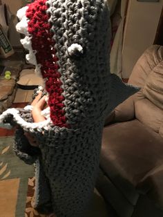 a crocheted object is sitting on the floor in front of a couch and chair