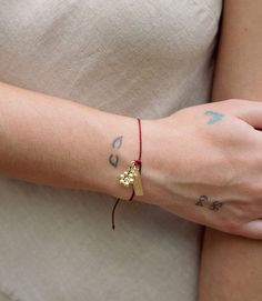 The Intention Bracelet - Gratitude features a hand beaded flower and a brass charm etched with the word “gratitude” and set with a delicate CZ stone. The red cord, a meaningful color in many cultures, adjusts with a pull-tie to accommodate most a variety of sizes. It serves as a daily reminder to the wearer to cultivate a sense of gratitude—whatever that may mean to them. Wear or gift a single intention bracelet or together with others to create a meaningful stack! Dimensions: Adjustable length bracelet, charm 0.75"L, 0.25" W Materials: Brass Care Instructions: Clean with jewelry cleaner product or with water and mild soap. Intention Bracelets, Brass Charms, Bracelet Charm, Jewelry Cleaner, Cz Stone, Daily Reminder, Hand Beading, Mild Soap, Gratitude