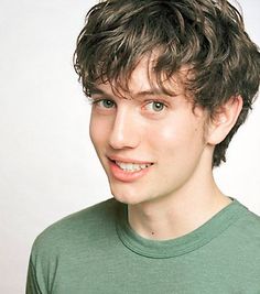 a close up of a person wearing a green shirt