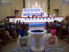 people are sitting in pews at the front of a church with a large boat on it