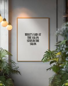 a framed poster hanging on the wall next to potted plants