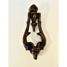 an antique door handle with ornate carvings on it's sides, mounted against a white wall