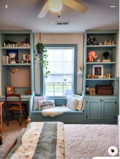 a bed sitting under a window next to a book shelf filled with lots of books