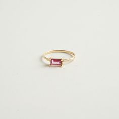 From our birthstone collection this exquisite natural ruby features a rare and delicate pink hue, radiating elegance and sophistication.  Celebrate the vibrancy of July with this stunning emerald-cut ruby crafted in 14K gold. Materials:  14K Solid gold .35 ct. Natural Ruby .79 Gold grams    Care Instructions: Storage: Store your jewelry in a cool, dry place, preferably in a fabric-lined jewelry box or pouch. Keep pieces separate to avoid scratching. Avoid Chemicals: Keep your jewelry away from harsh chemicals, such as bleach, chlorine, and household cleaners. These can damage metals and dull gemstones. Regular Cleaning: Clean your jewelry regularly with appropriate methods to maintain its brilliance and prevent buildup of oils and dirt. Timeless Emerald-cut Ruby Ring, Pink Ruby Ring With Diamond Accents, Luxury Ruby Baguette Cut Jewelry, Delicate Emerald Cut Yellow Gold Jewelry, Luxury Ruby Jewelry Radiant Cut, Elegant Emerald Cut Tourmaline Jewelry, Luxury Radiant Cut Ruby Jewelry, Baguette Cut Tourmaline Jewelry For Weddings, Pink Ruby Ring Fine Jewelry Birthstone