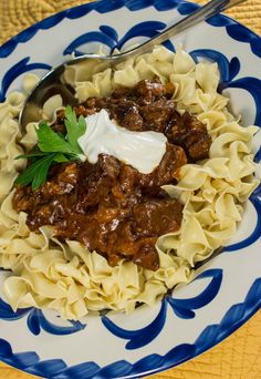 pasta with meat and sauce in a blue and white bowl