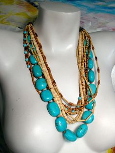 "Original multi strand chunky necklace design, featuring a strand of stabilized turquoise nuggets separated by wood beads and nine strands of round turquoise beads, tiny wood and bamboo beads in different sizes and shapes, providing warmth and spice to the cool turquoises. Necklace's longest strand is 27\" long, including the elegant Bali sterling silver toggle clasp, cones and chain at the ends and has been strung on flexible nylon coated stainless steel stringing wire for strength and durability.  Turquoise is December's birthstone. My sterling silver hand stamped maker's mark tag hangs from end of necklace.  Handmade in the USA by Lia Galletti at the LIA Jewelry Designs studio in Fort Myers, FL A distinctive statement of taste any time of day or night which will make you proud to wear o Cheap Multi-strand Jewelry, Turquoise Beaded Nature-inspired Necklace, Turquoise Beaded Necklace With Nature-inspired Style, Unique Multi-strand Turquoise Necklace, Artisan Turquoise Necklace With Wooden Beads, Bohemian Multi-strand Turquoise Necklace With Large Beads, Unique Turquoise Multi-strand Beaded Necklaces, Bamboo Beads, Jewelry Design Studio