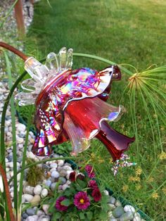 a glass flower is sitting in the grass